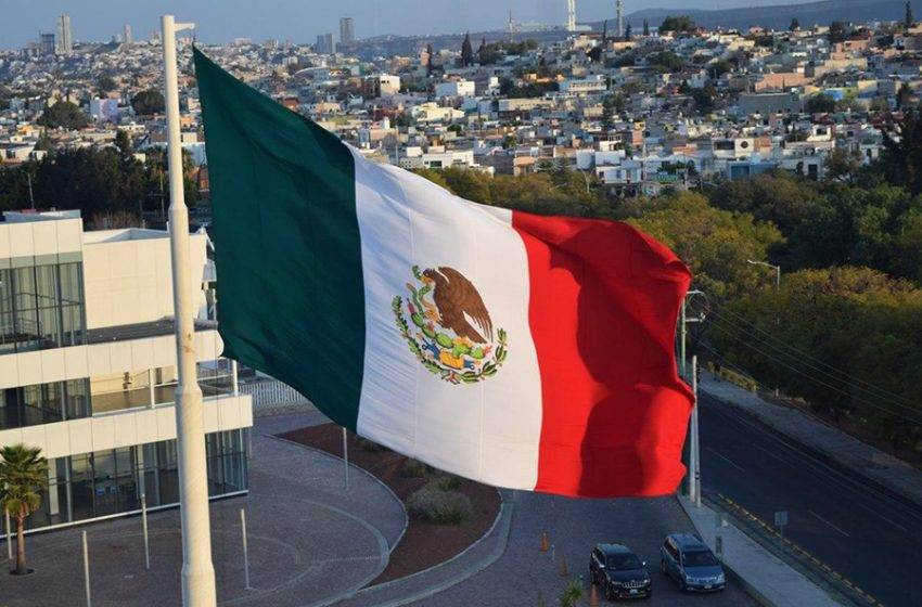 Mexican flag waving proudly over a city
